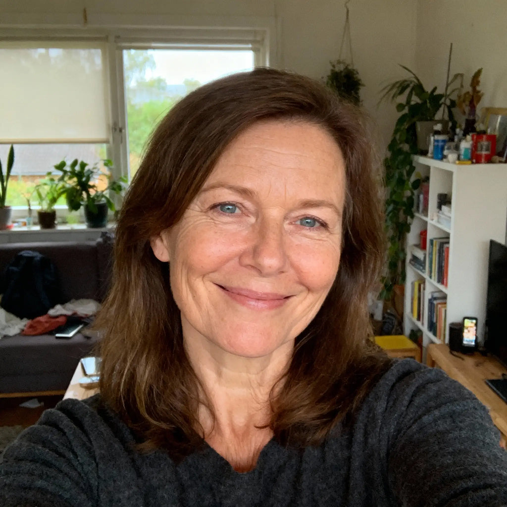 Leende kvinna i rum med växter och bokhyllor